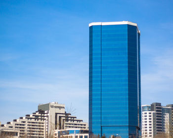 Low angle view of modern buildings against blue sky