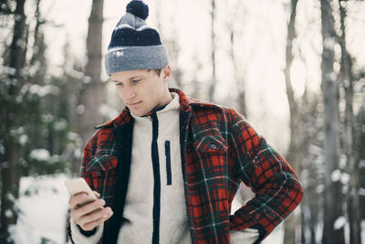 Midsection of man standing on snow covered tree