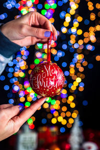 Close-up of hand holding illuminated christmas lights