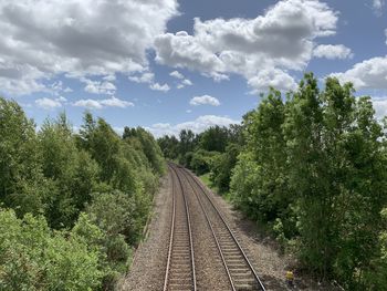 View of railroad tracks amidst trees against sky