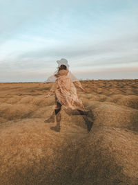 Multiple exposure image of young woman running on field