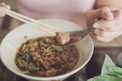 Close-up of hand holding rice in bowl