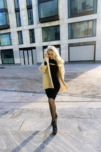 Portrait of young woman standing on street