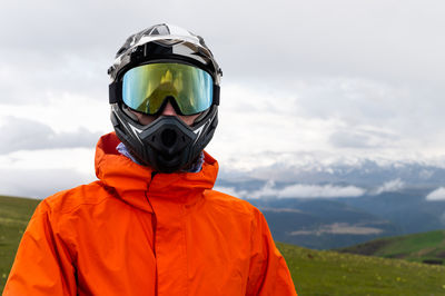 Rear view of man wearing warm clothing standing against mountain