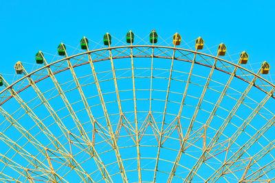 Low angle view of ferris wheel against blue sky