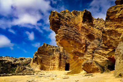 Rock formation on mountain against cloudy sky