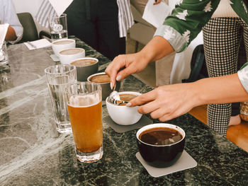 Cropped image of man holding coffee cup on table