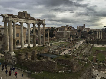 Tourists at town square against cloudy sky