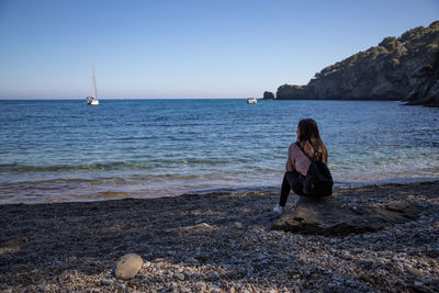 Rear view of woman standing at beach