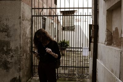 Side view of woman standing by window in building