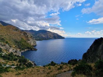 Scenic view of sea and mountains against sky
