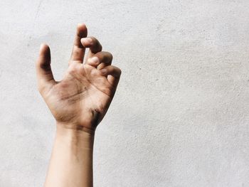 Cropped image of person hand against wall