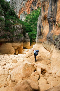 Side view of backpack man hiking at rocky mountains