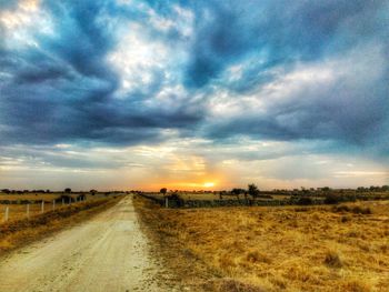 Scenic view of agricultural field against sky during sunset