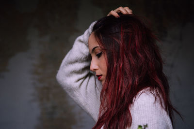 Side view of woman with hand in hair