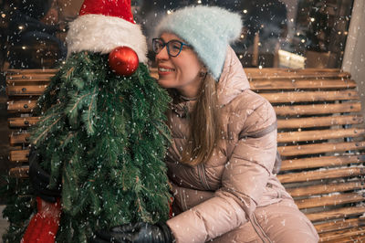 Portrait of smiling woman with christmas tree