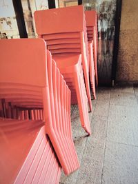 Stack of red chairs in building
