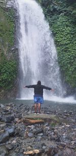 Rear view of man splashing water