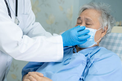 Midsection of doctor examining patient in hospital