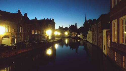 Canal amidst buildings against sky at night