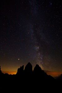 Low angle view of silhouette mountain against sky at night