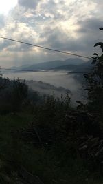 View of calm lake against cloudy sky