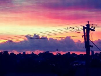 Silhouette of power lines against cloudy sky