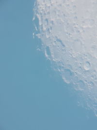 Low angle view of frozen water against clear blue sky