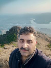 Portrait of young man against mountain