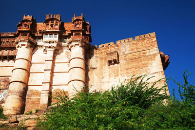 Low angle view of mehrangarh fort against clear blue sky
