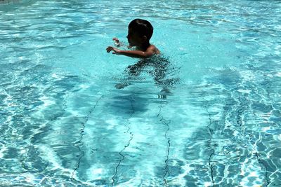 High angle view of boy swimming in pool