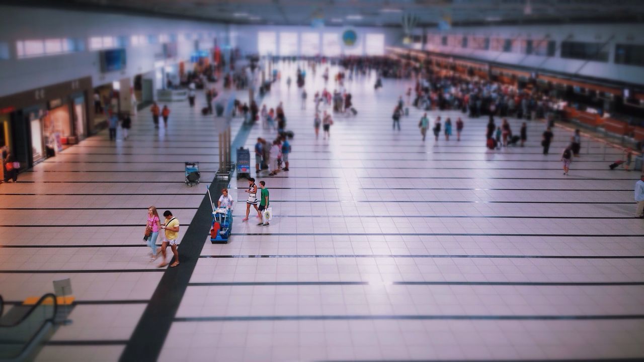 indoors, large group of people, built structure, architecture, illuminated, railroad station, walking, person, escalator, the way forward, diminishing perspective, city life, men, subway station, transportation, railroad station platform, in a row, incidental people, selective focus