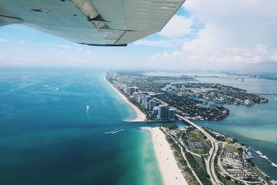 Aerial view of sea and cityscape against sky