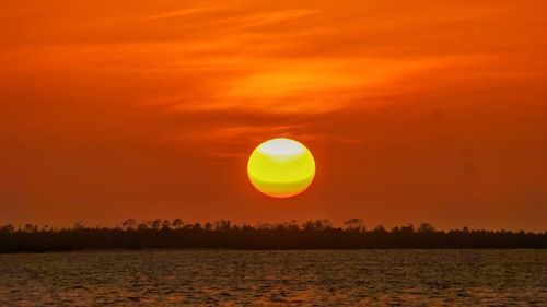 Scenic view of sea against orange sky