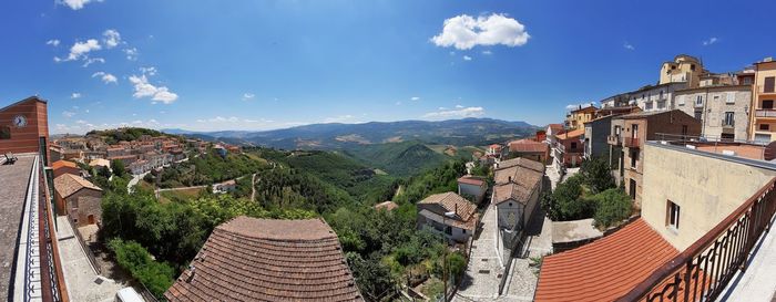 Panoramic view of buildings in town against sky