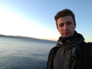 Portrait of man standing at beach against clear sky