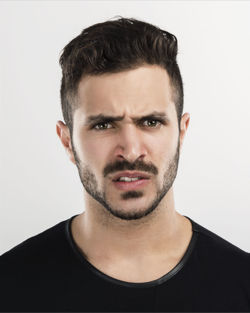 Close-up portrait of young man against white background