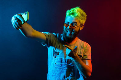 Young man wearing mask against blue background