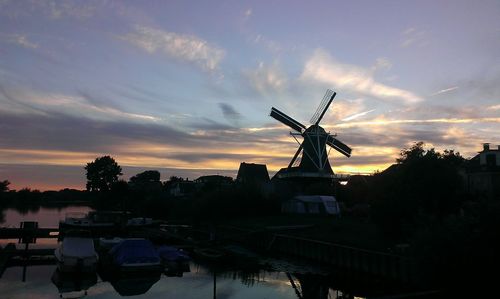 Silhouette of traditional windmill against sky during sunset