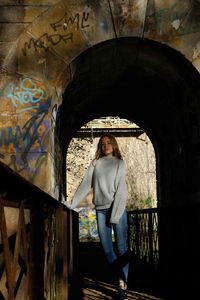 Portrait of woman standing against wall