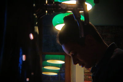 Portrait of young man looking at illuminated lights