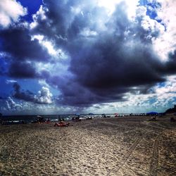 Scenic view of beach against cloudy sky