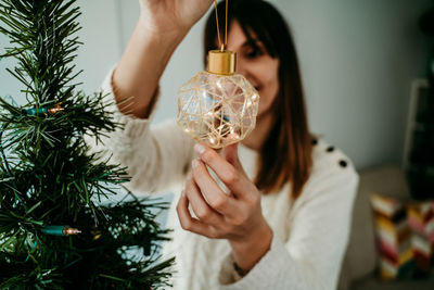 Midsection of woman holding christmas tree