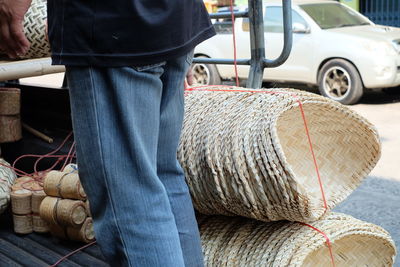 Midsection of man loading wicker baskets on vehicle