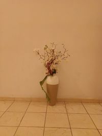 Flower vase against wall at home