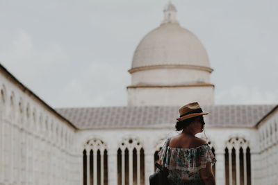 Rear view of woman looking at building against sky