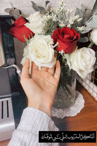 Close-up of hand holding rose bouquet