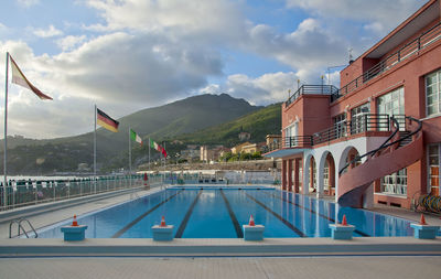 Swimming pool by mountains against sky