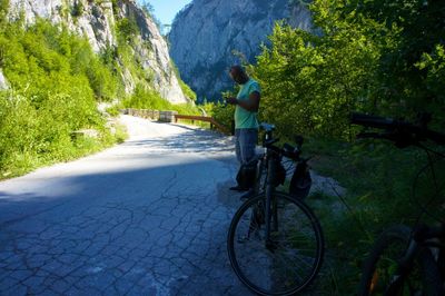 Rear view of people riding bicycle on mountain