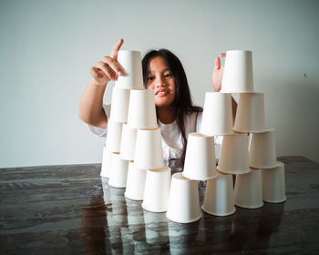 Smiling girl stacking glasses on table